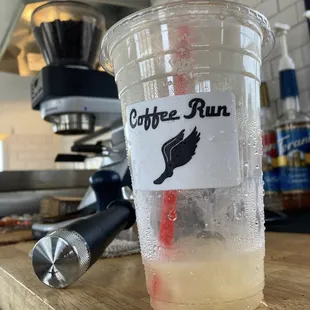 a cup of coffee with a straw and a spoon