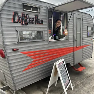 a smiling woman looking out the window