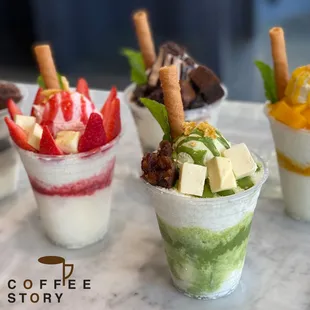 a variety of desserts in cups