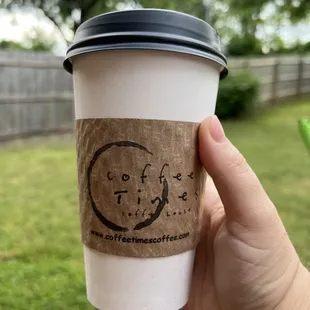 a hand holding a coffee cup