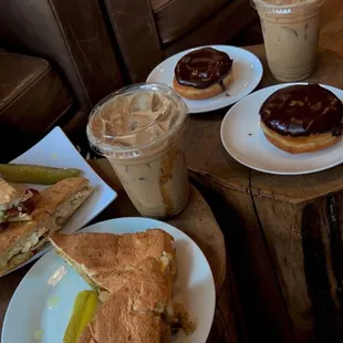 coffee, sandwiches and doughnuts on a table