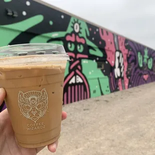 a hand holding a cup of iced coffee