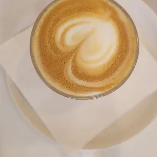 a latte in a glass on a napkin