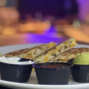 a plate of quesadillas and dips