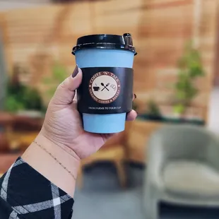 a hand holding a cup of coffee