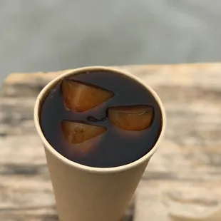 a cup of coffee with ice cubes in it
