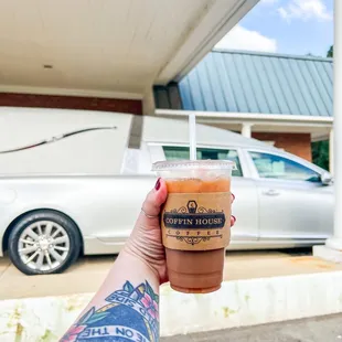 a hand holding a cup of coffee