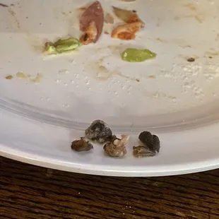 Olive pits left on our pizza! This was on my fiancé's plate. I also had to spit out a pit on one of my slices!