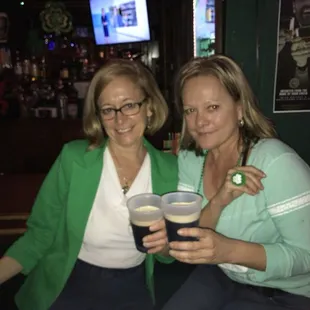two women holding drinks