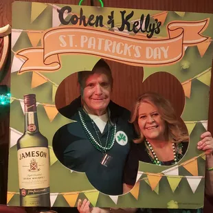 a man and a woman holding up a st patrick's day sign