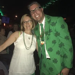 a man in a green suit and a woman in a white top