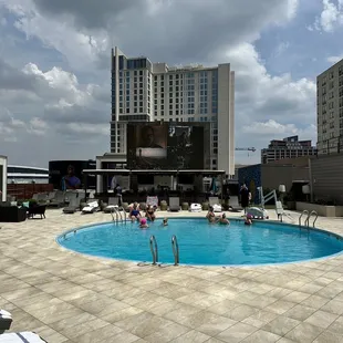 a swimming pool with lounge chairs in the foreground