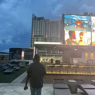 a man standing in front of a large screen