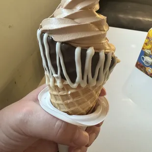 Chocolate soft serve in a dipped waffle cone.