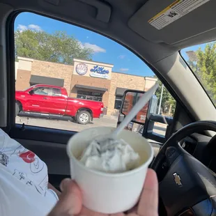 a hand holding a cup of ice cream