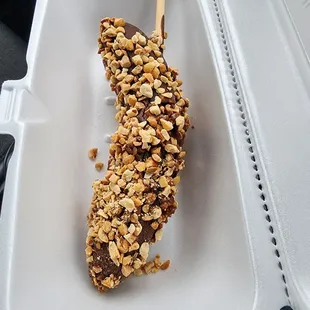 a chocolate covered ice cream bar in a styrofoam container
