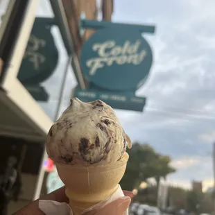 a hand holding an ice cream cone