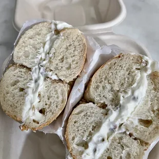 two bagels with white sauce on them
