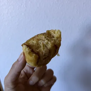 a hand holding a half eaten pastry