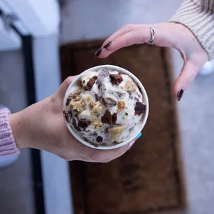 a person holding a cup of ice cream