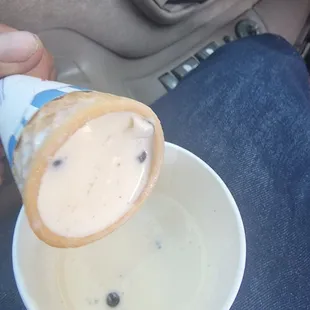 a person holding a cup of ice cream
