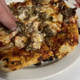 a hand grabbing a slice of pizza