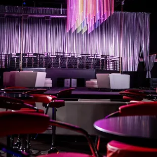 a stage with chairs and a stage curtain