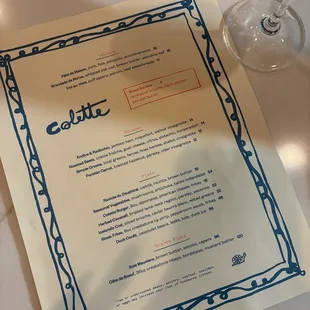 a menu and a glass of orange juice