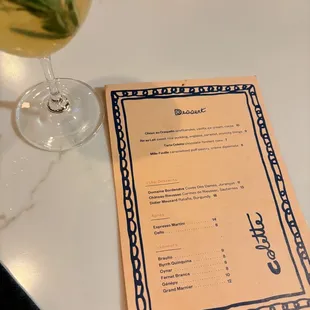 a menu and a glass of wine