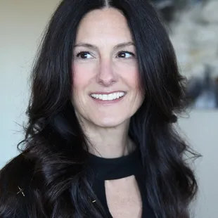 a smiling woman with long dark hair