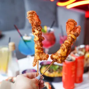 a person holding a skewer of chicken