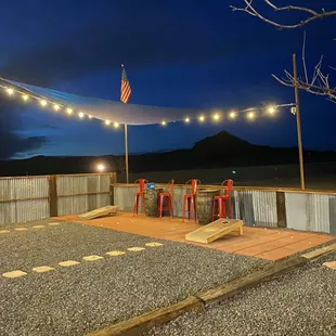 a patio with red stools