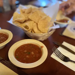 a bowl of salsa and a bowl of tortillas