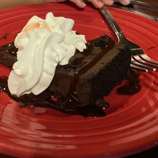 a piece of chocolate cake on a red plate