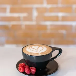 a cup of coffee and raspberries