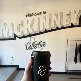 a hand holding a cup of coffee