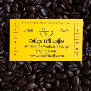 a yellow business card on a pile of coffee beans