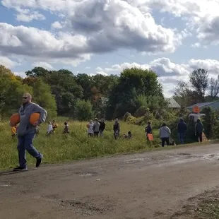 a group of people walking down a dirt road
