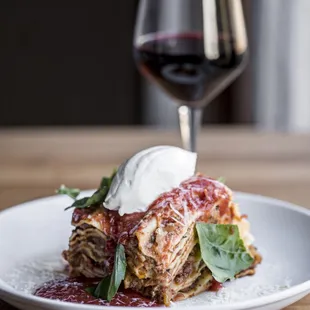 a plate of lasagna and a glass of wine