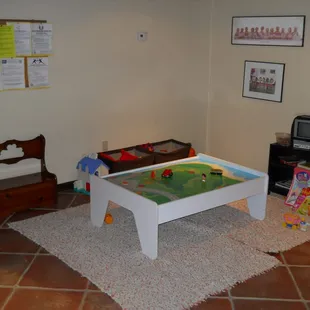 The children's play area is full of toys while they wait.