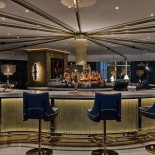 a bar with a circular counter and blue chairs