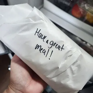 a hand holding a piece of paper that says have a great lunch