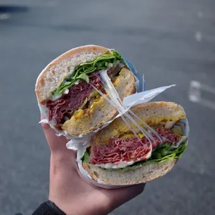 a hand holding a sandwich