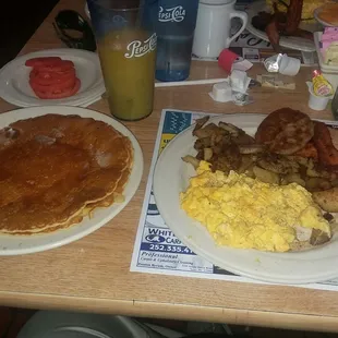 Hungry Henry Breakfast. Scrambled eggs with cheese, home fries, and a side of sliced tomato. And OJ.