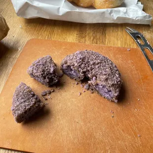 a wooden cutting board with a piece of doughnut on it