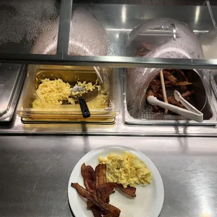 a plate of bacon, eggs, and hash browns