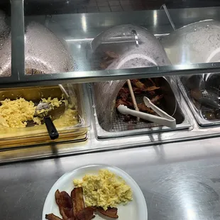a breakfast buffet with eggs, bacon, and hash browns