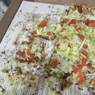 Uneaten pizza with tiny bacon crumbles.