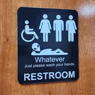 a restroom sign on a wooden door