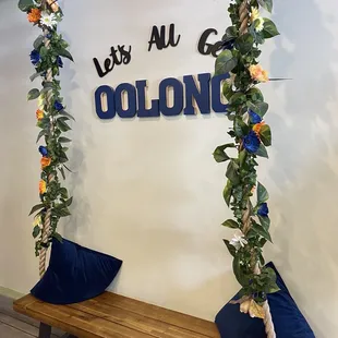 a wooden bench with flowers and a sign that says let's all go colorado